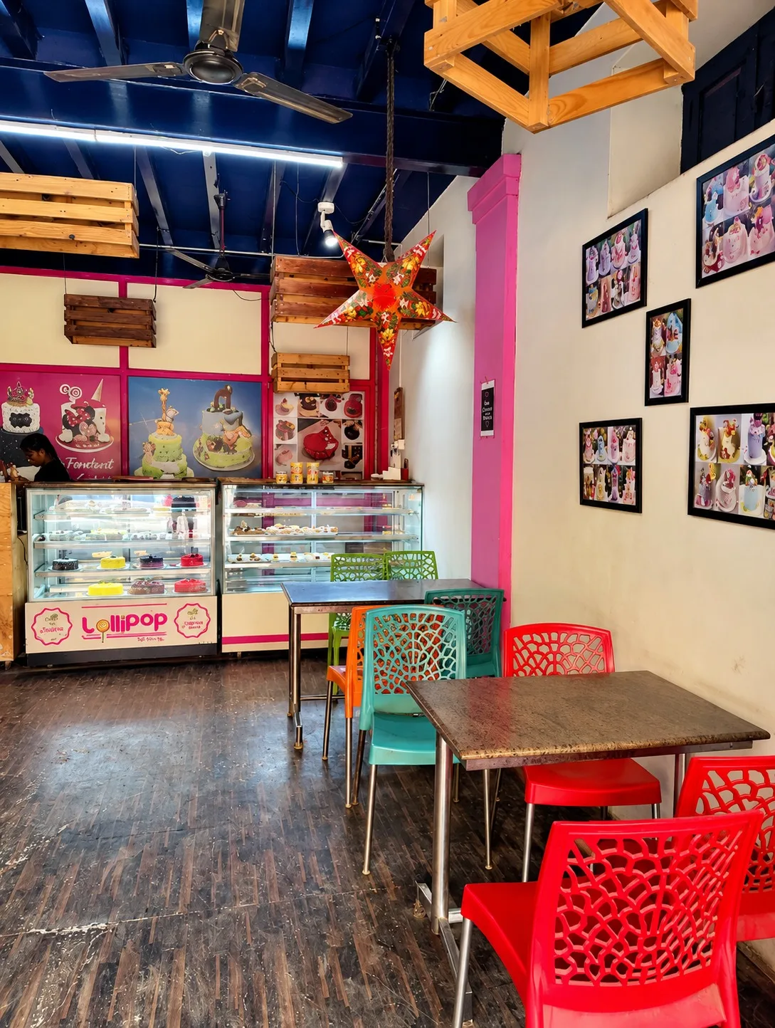 Seating area inside Lollipop with colourful chairs and framed custom cake photos